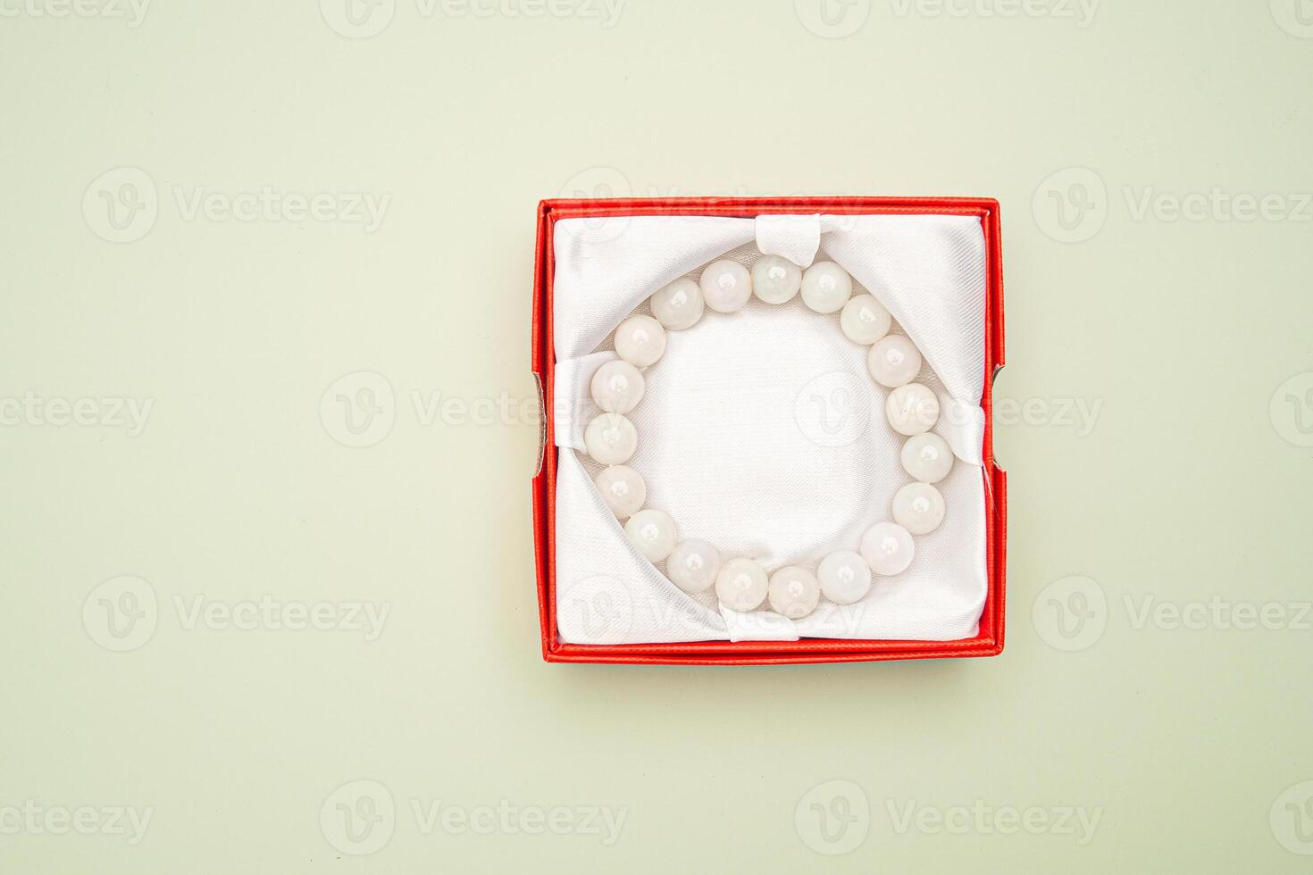 Top view fo jade bangle or bracelet in a red box on a green background. photo