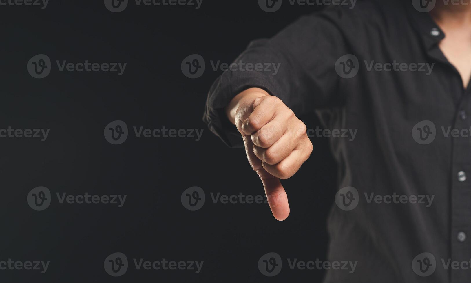 Negative feedback concept. Close-up of a hand showing a thumbs down for dissatisfaction with service photo