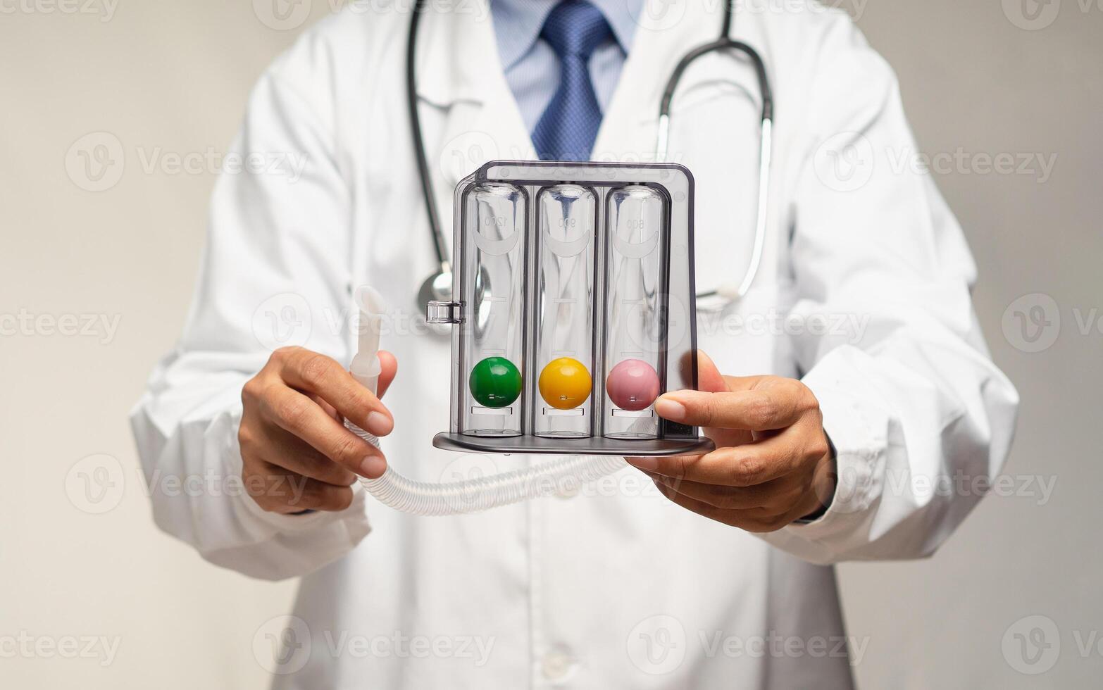 Doctor holding an incentive spirometer to help perform deep breathing exercises while standing in the hospital. photo