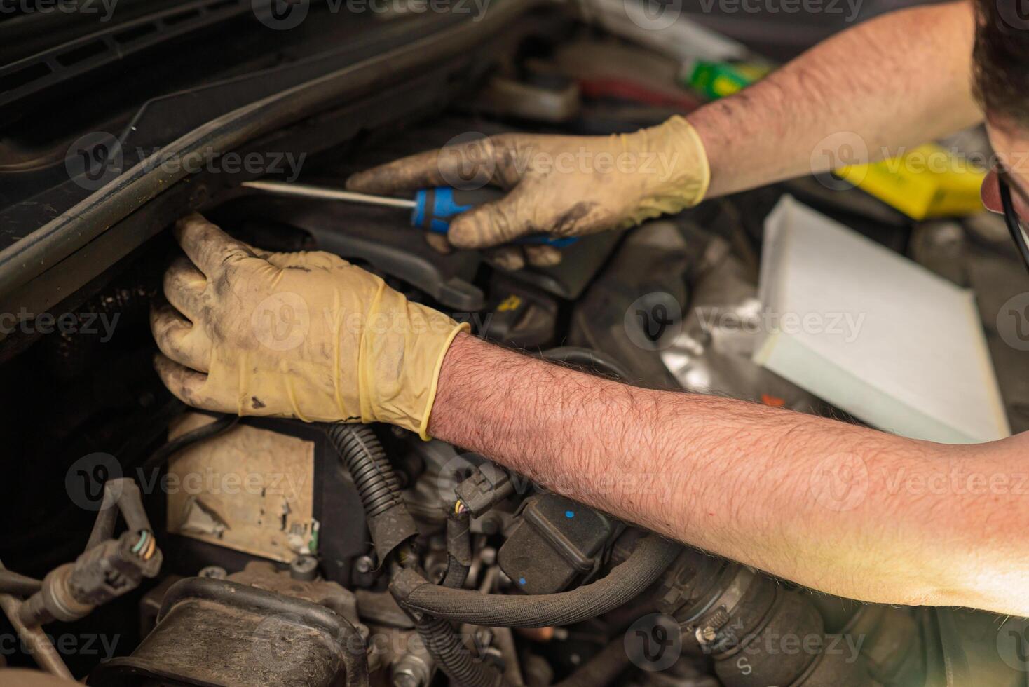 hands of a mechanic repairing the engine of a diesel car in a mechanical workshop photo