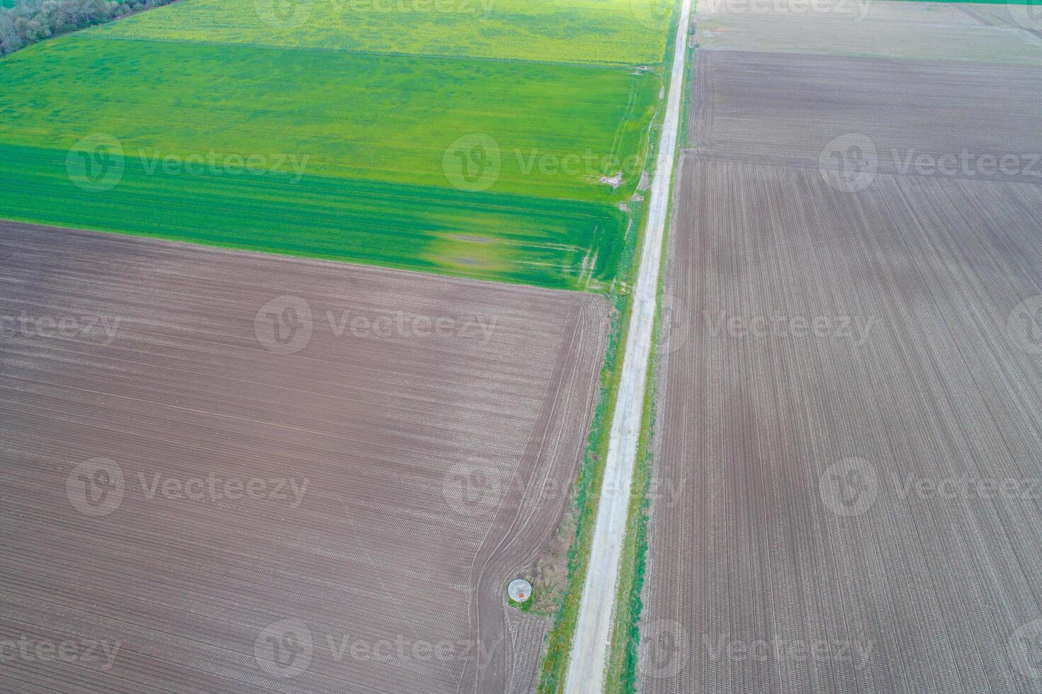drone aerial view of a road between plowed fields in springtime, agricultural background concept photo