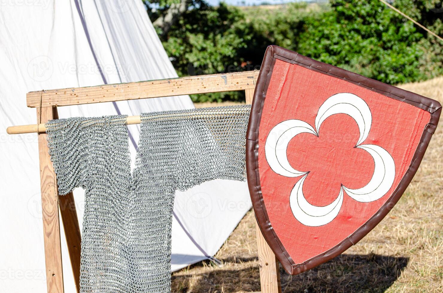 close view of a medieval shield and hanging chainmail shirt at a historical recreation party event photo