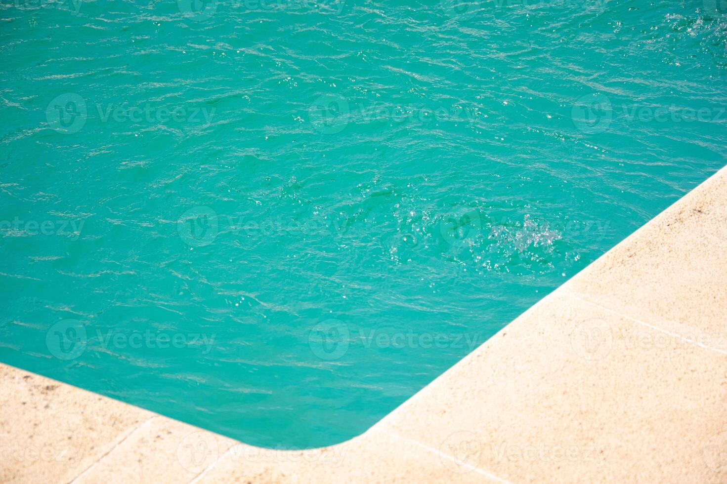 corner of a swimming pool with clear blue water photo