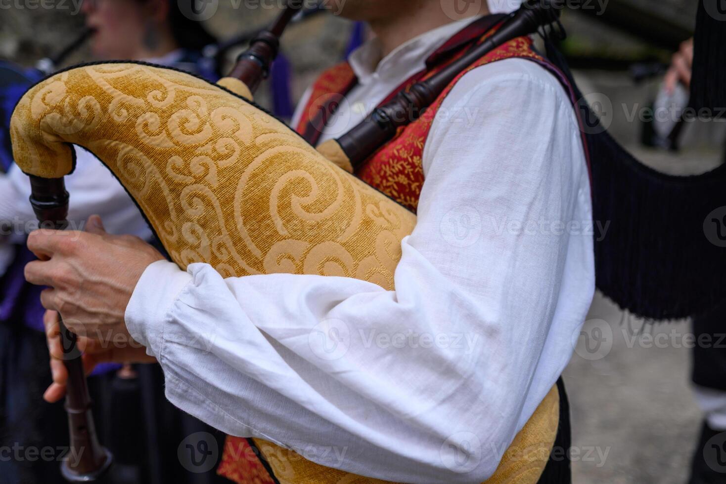 musician playing decorated traditional yellow bagpipe during a popular festival in Galicia photo