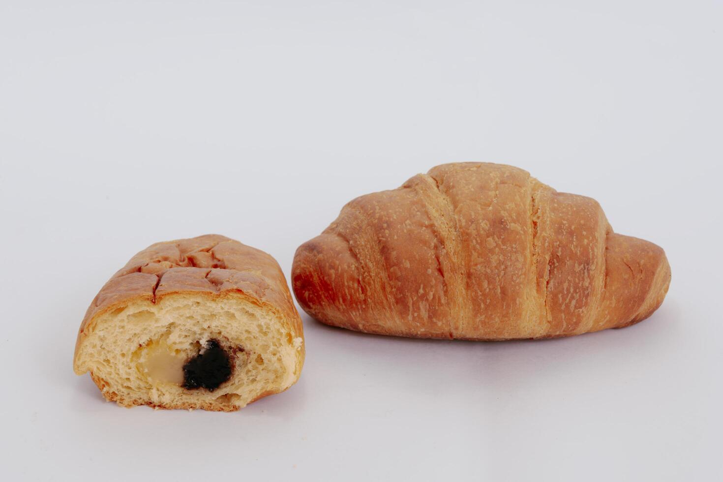 Sliced croissant with bananas and chocolate isolated on white background. photo