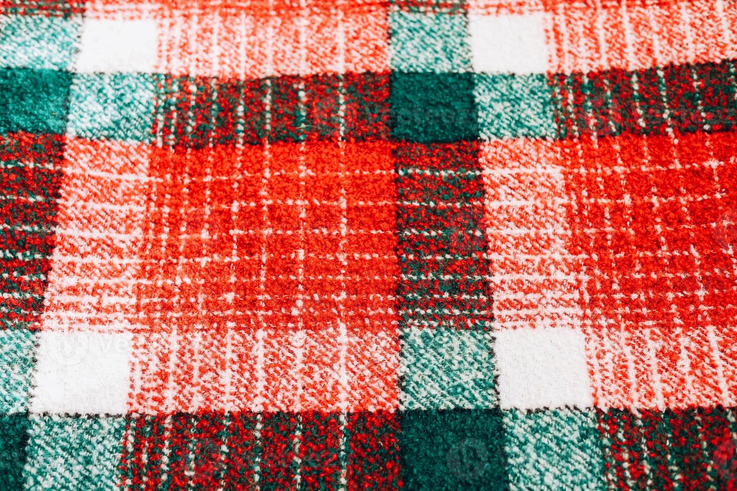 Colorful plaid fabric with red and green checkered pattern on a soft surface photo