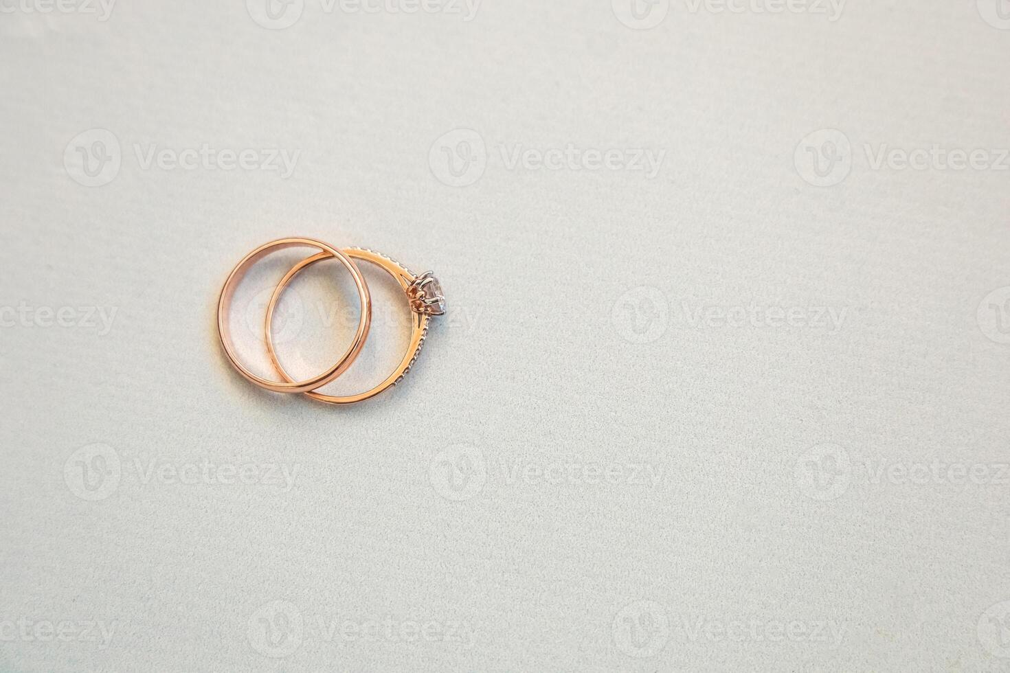Elegant gold and diamond wedding rings arranged on a soft surface in a well-lit setting photo