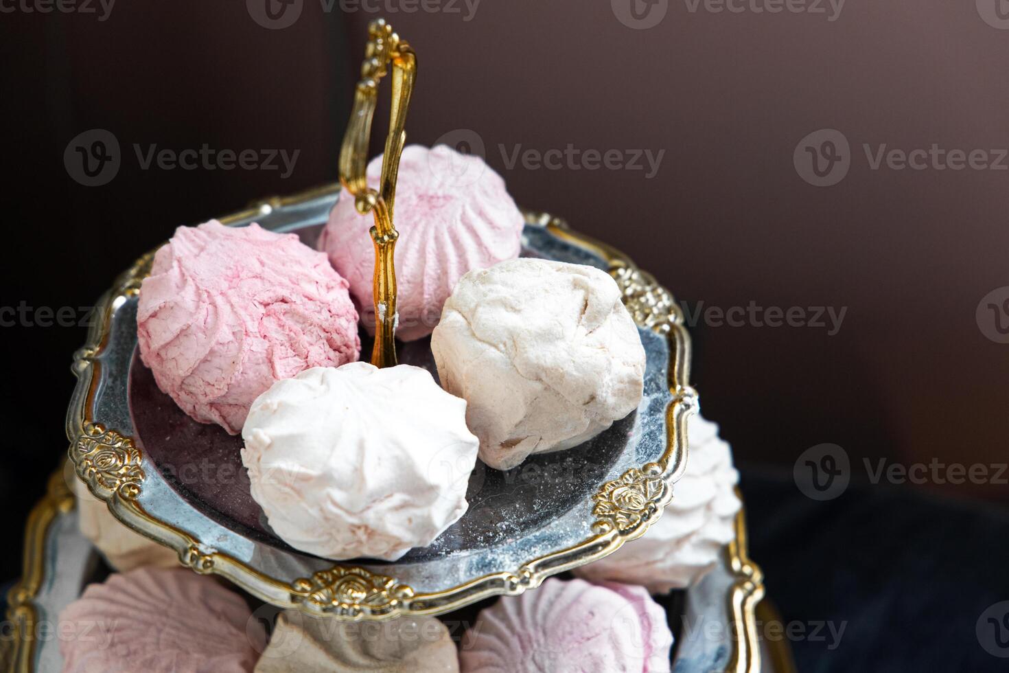 Delicious meringue cookies arranged on an elegant serving tray in soft colors photo