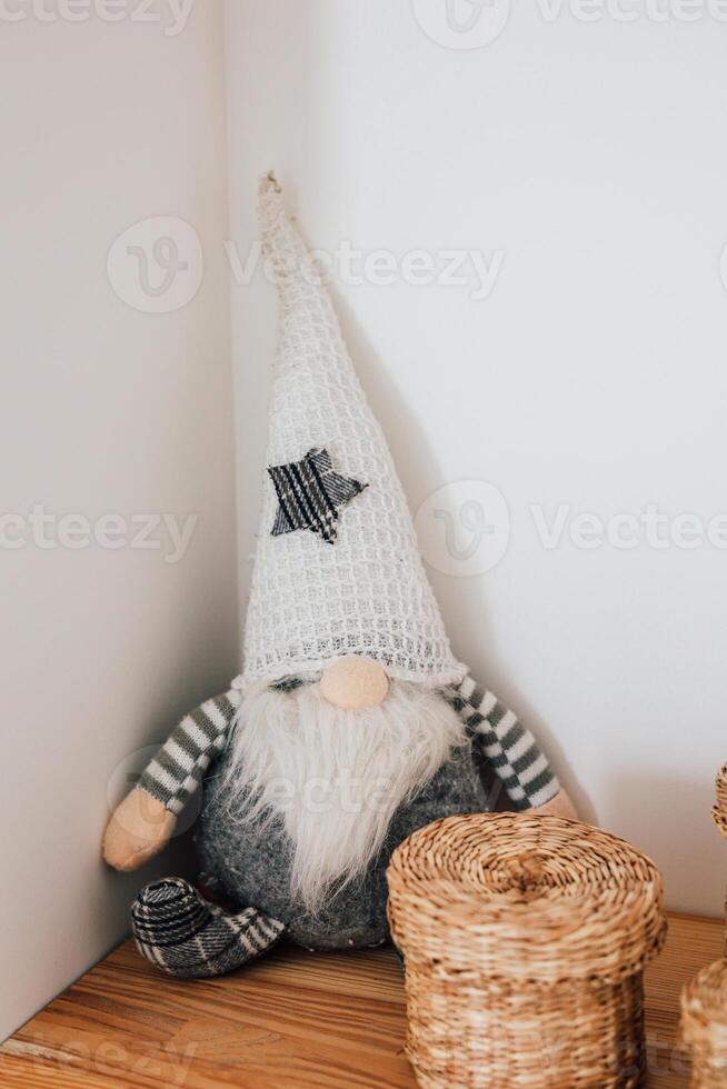 Decorative gnome sitting on wooden shelf surrounded by woven baskets and soft lighting photo