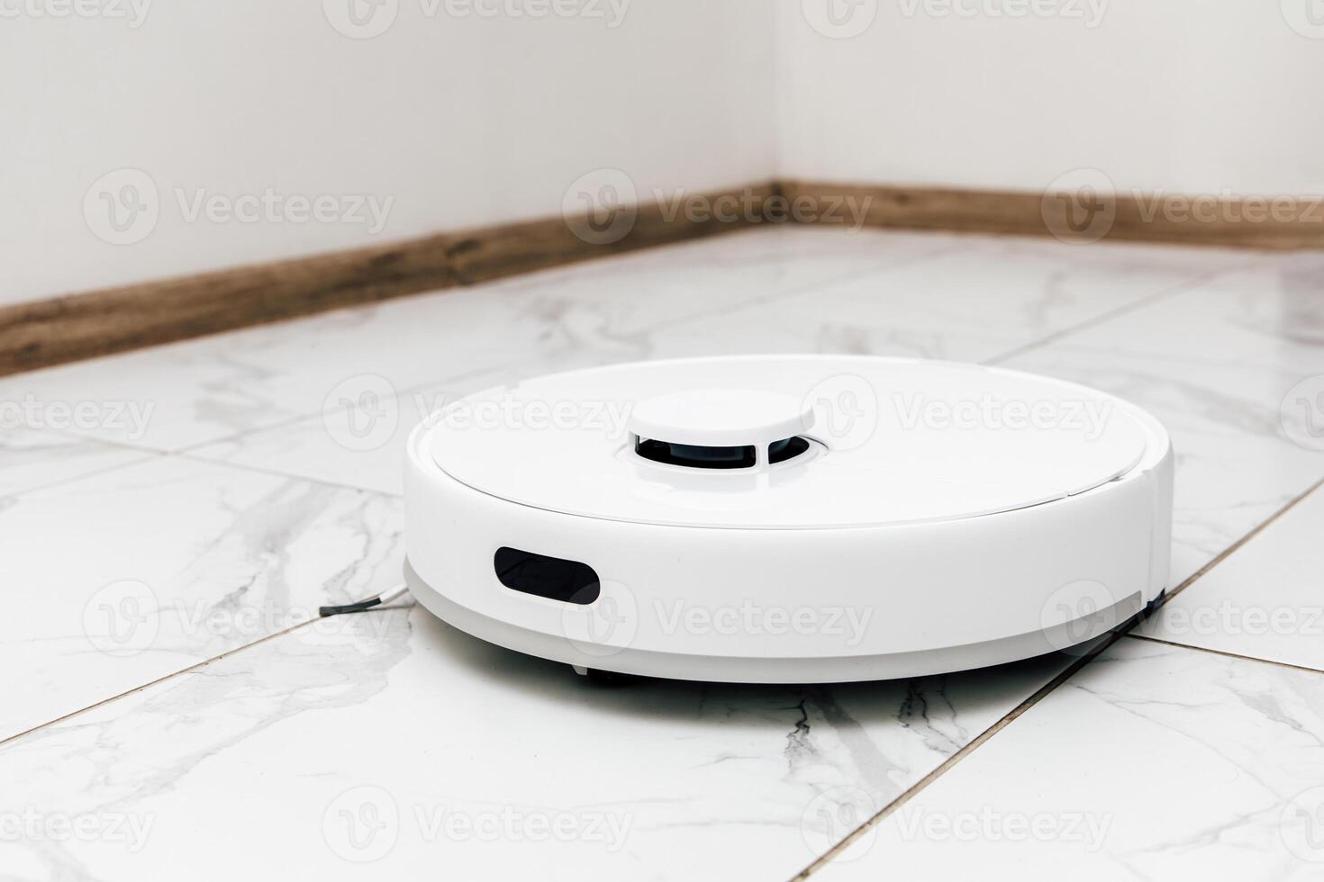 Robotic vacuum cleaner operating on tiled floor in modern home environment photo