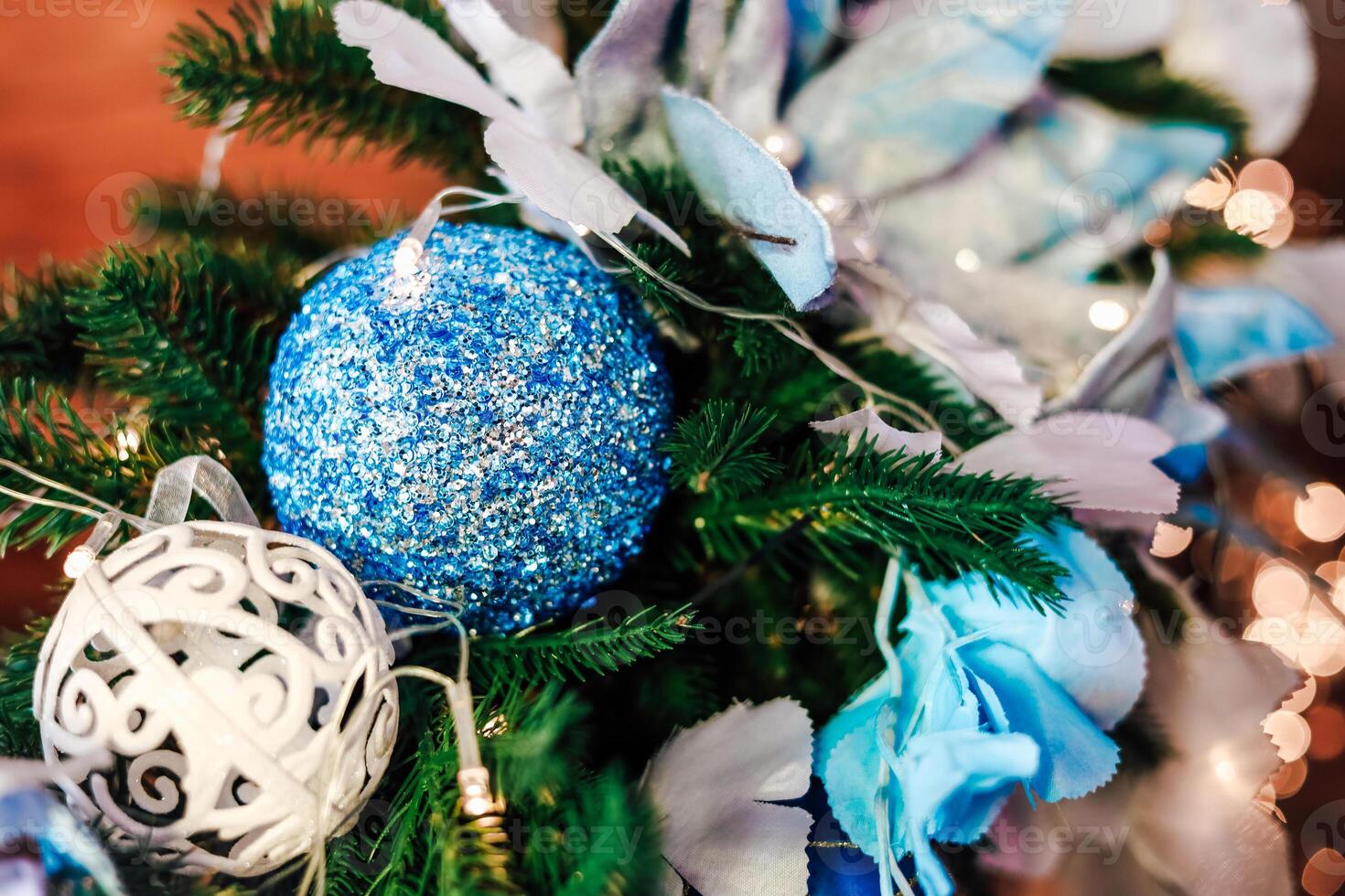 Decorative blue and silver ornaments on holiday greenery in festive decor setting photo