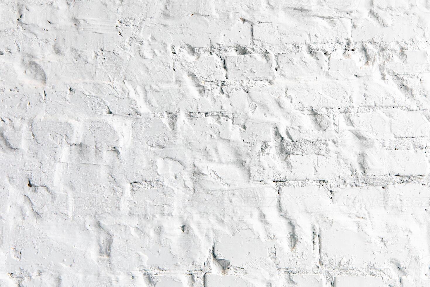 Textured white brick wall with subtle details and shadows in an indoor setting photo