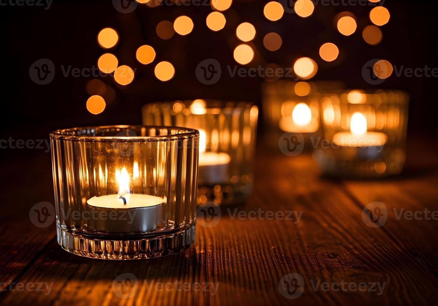 Burning candles in glass holders on table against blurred lights, space for text photo
