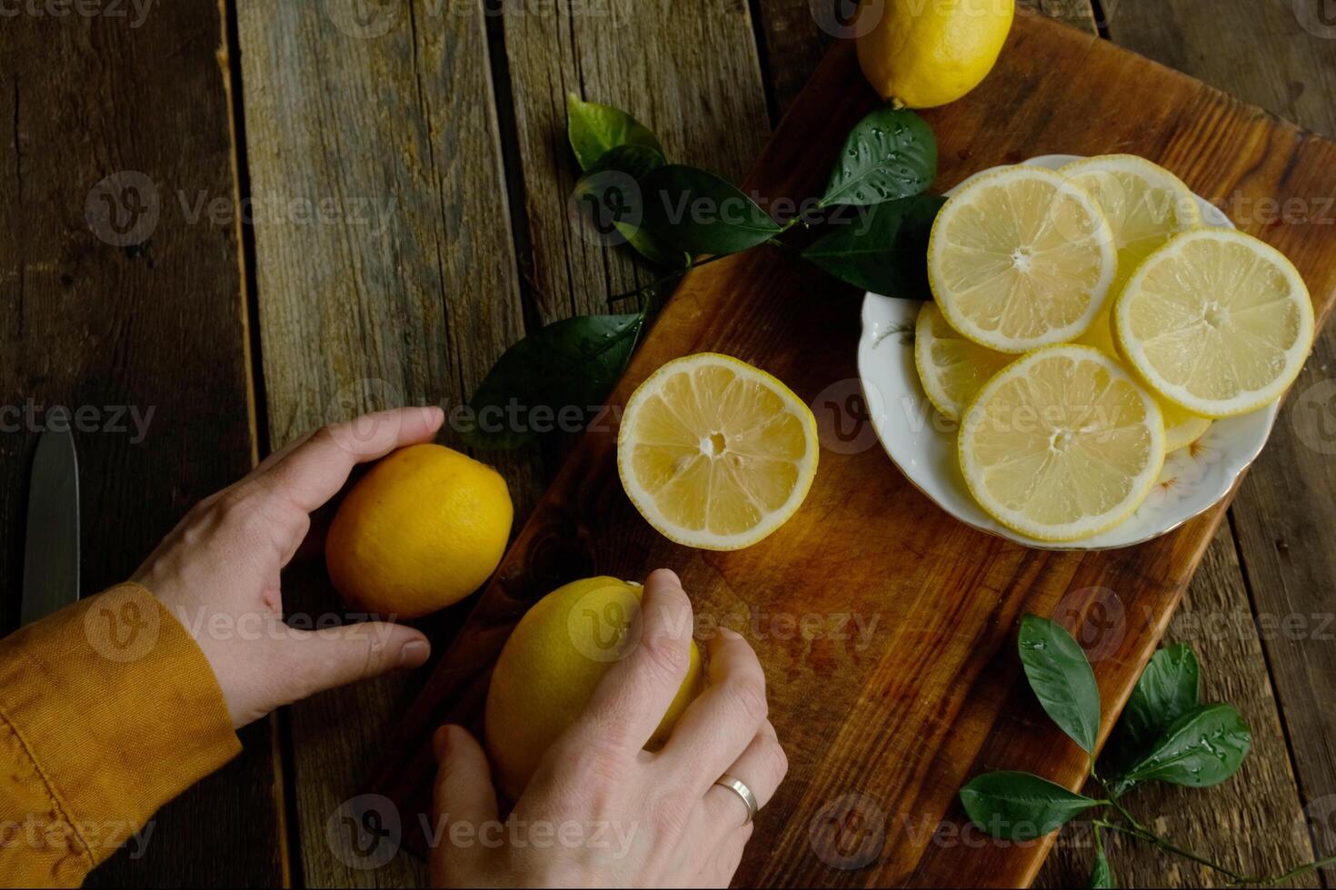 Slicing lemons. Preparing fresh lemons for summer lemonade. Top view. photo