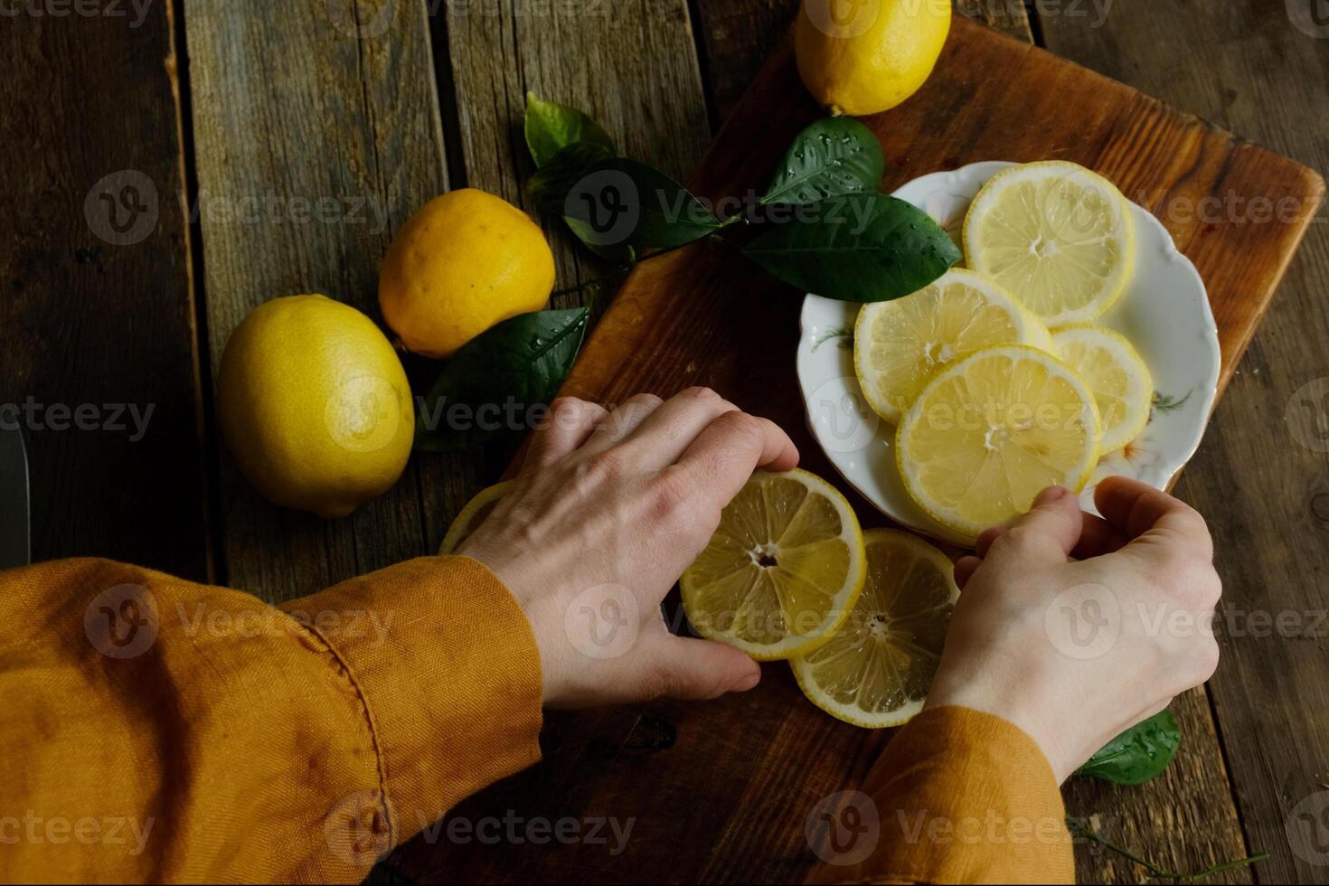 Slicing fresh lemons. Preparing ingredients for summer lemonade. Top view. photo