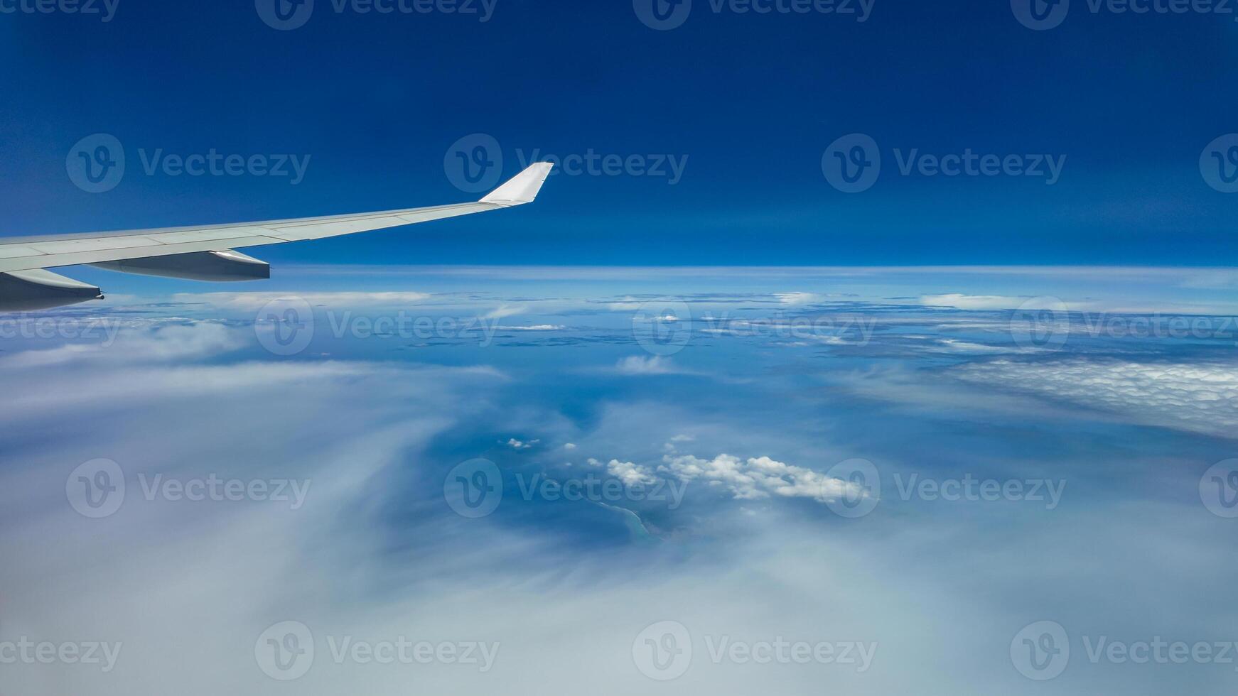 The view from the airplane window to the clouds. Airplane wing above thick blue and white clouds. Wonderful sky photo