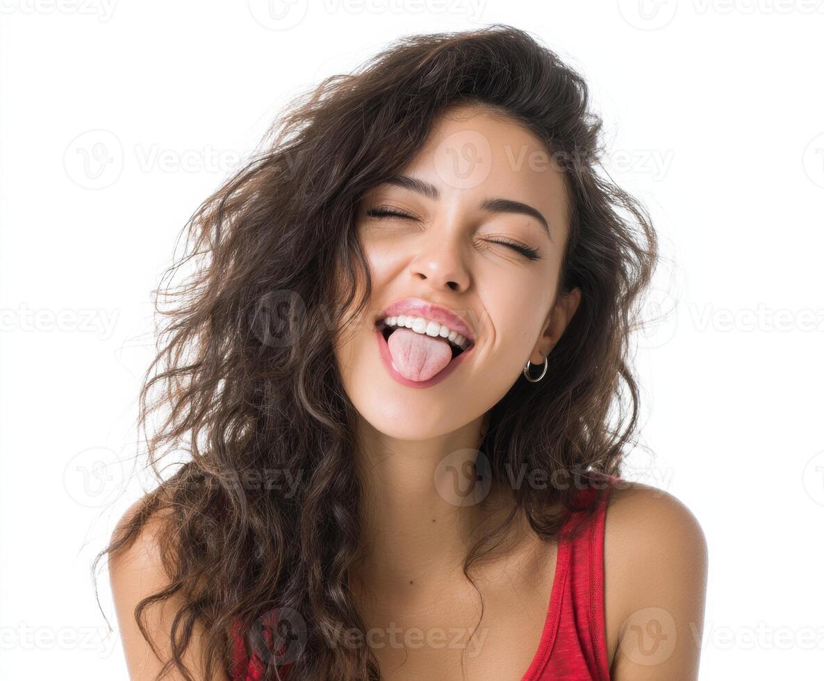 Playful young woman sticking out her tongue and smiling joyfully photo