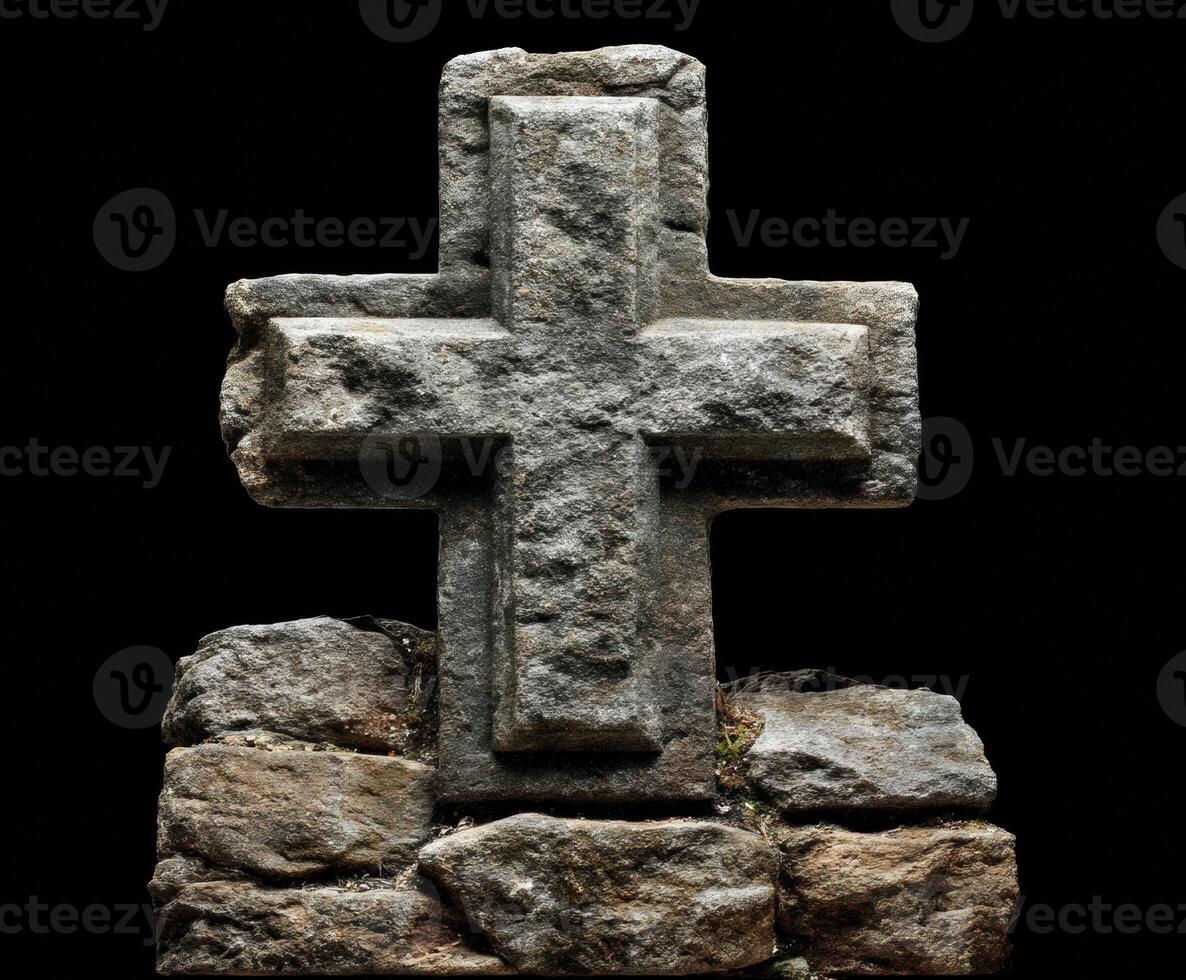 Medieval stone cross on rocky base in dark setting photo
