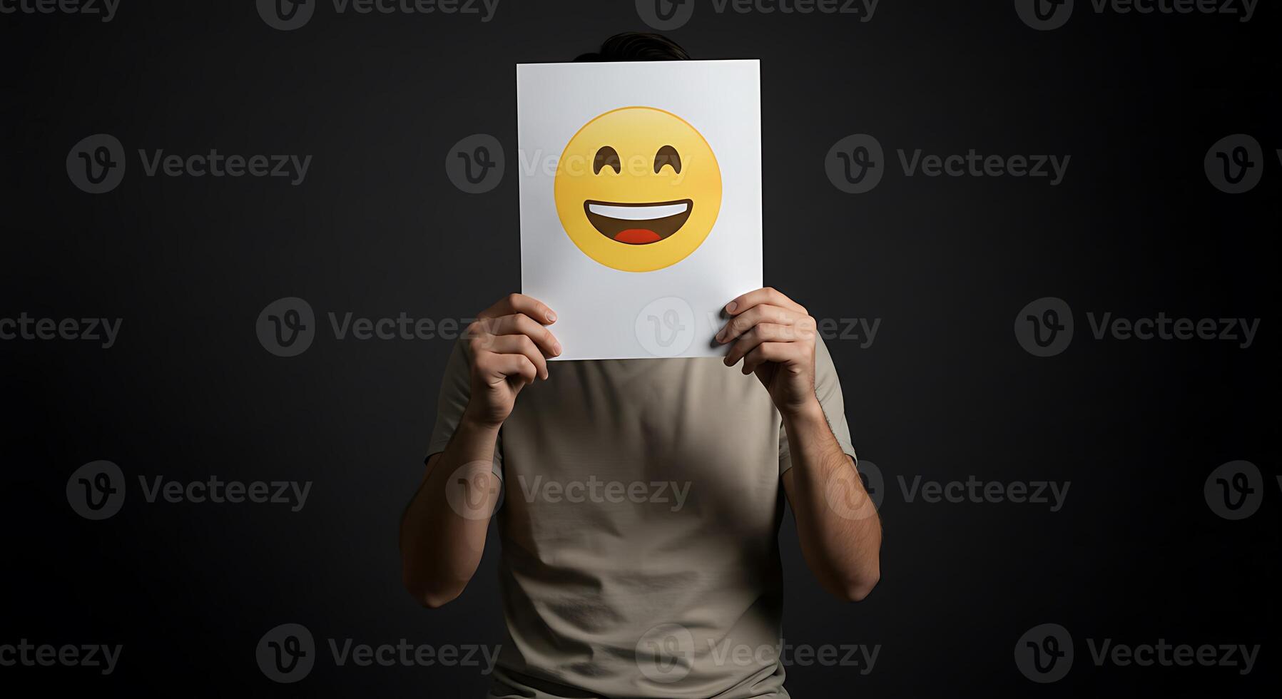 A man holding up a paper with an emoticor on it photo