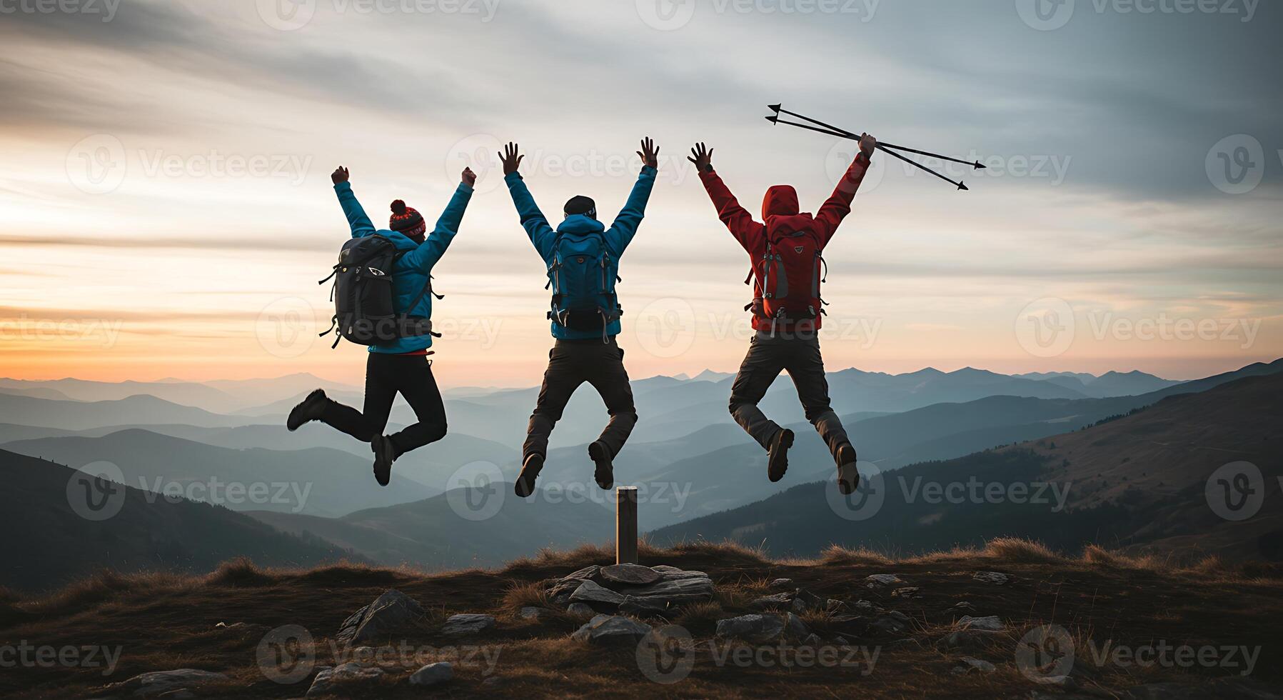Three people jumping on top of a mountain photo