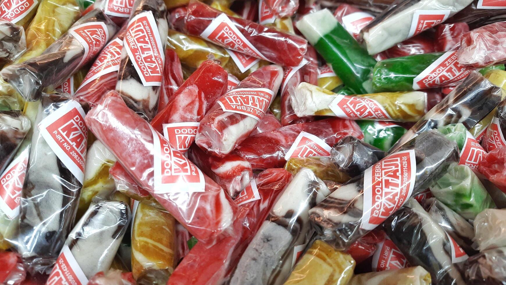 A pile of Dodol Garut Kataji snack for sale in supermarket. Dodol famous from Garut West Java. The taste sweetness. Jakarta, Indonesia - May 19 2025 photo