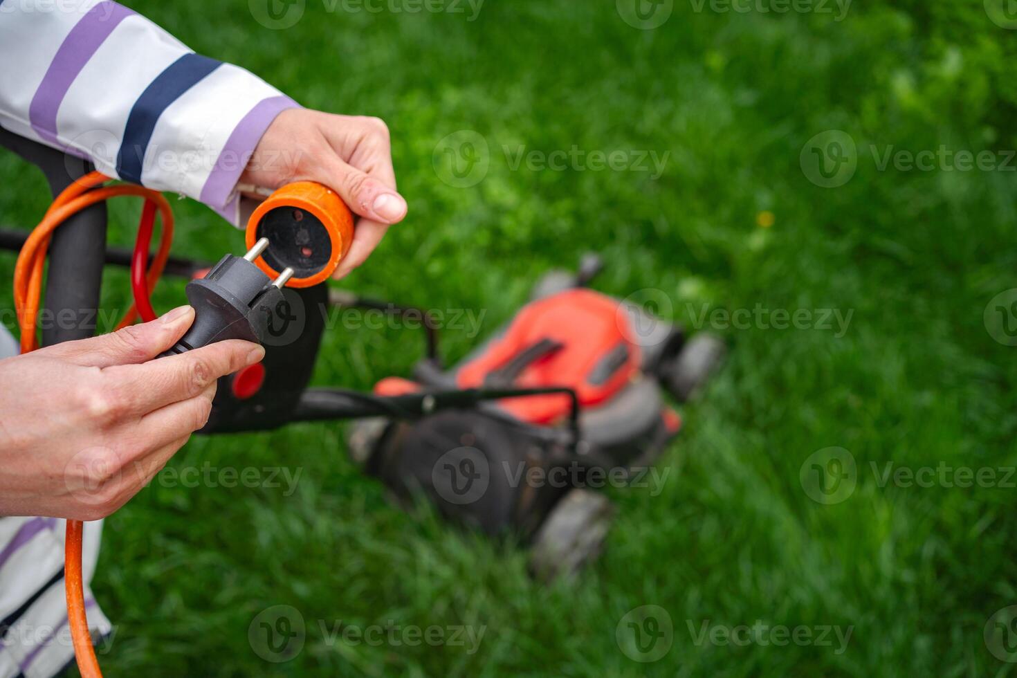 Preparing the electric lawn mower for a fresh cut in a sunny garden paradise photo