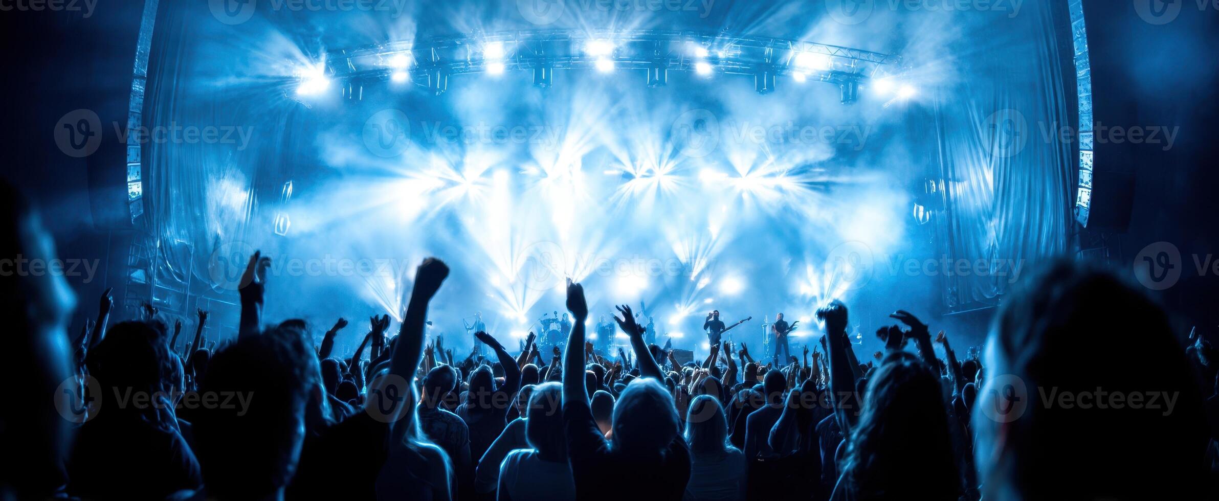 The vibrant concert scene with an energetic audience and stunning light display. photo