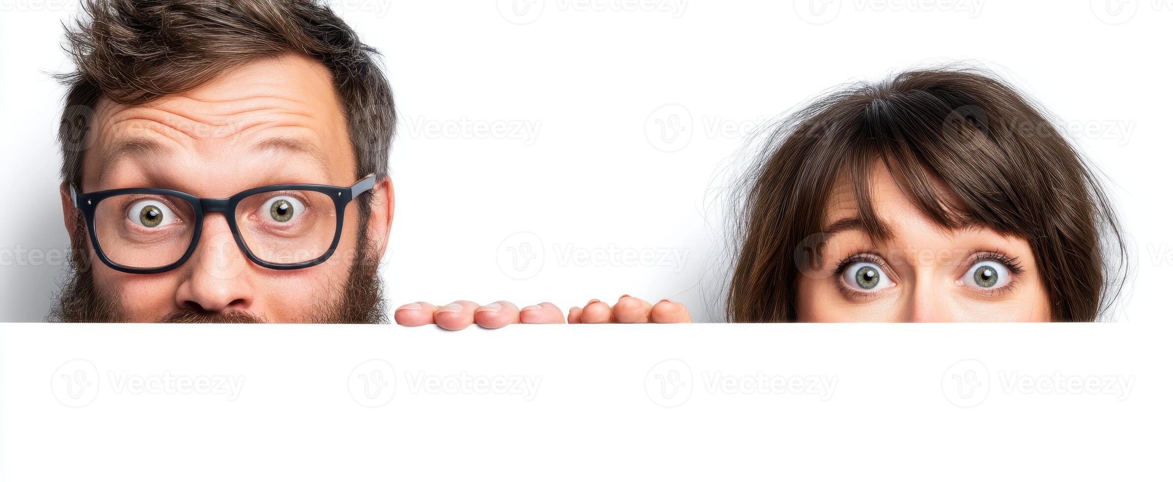 The Surprised Couple Peeking Over a White Surface with Playful Expressions photo