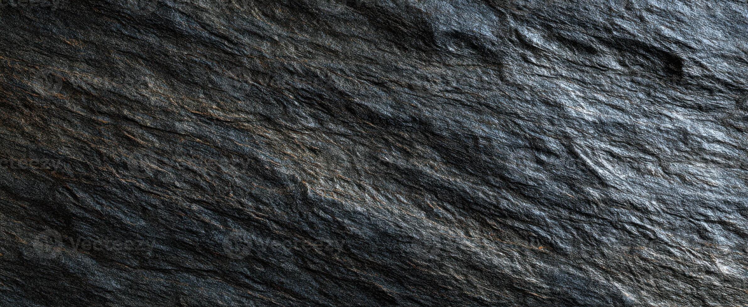 The textured slate rock surface showcasing its natural dark beauty and intricate patterns. photo