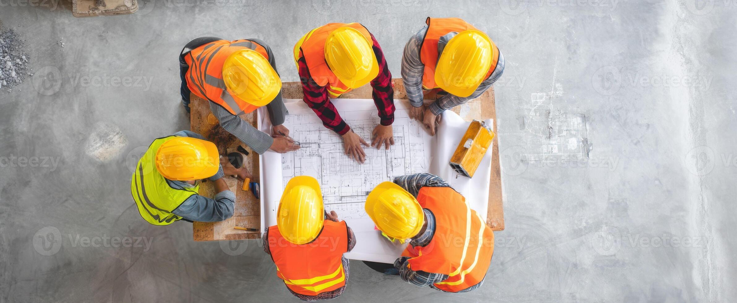 The construction team collaborating on blueprints for a new project. photo