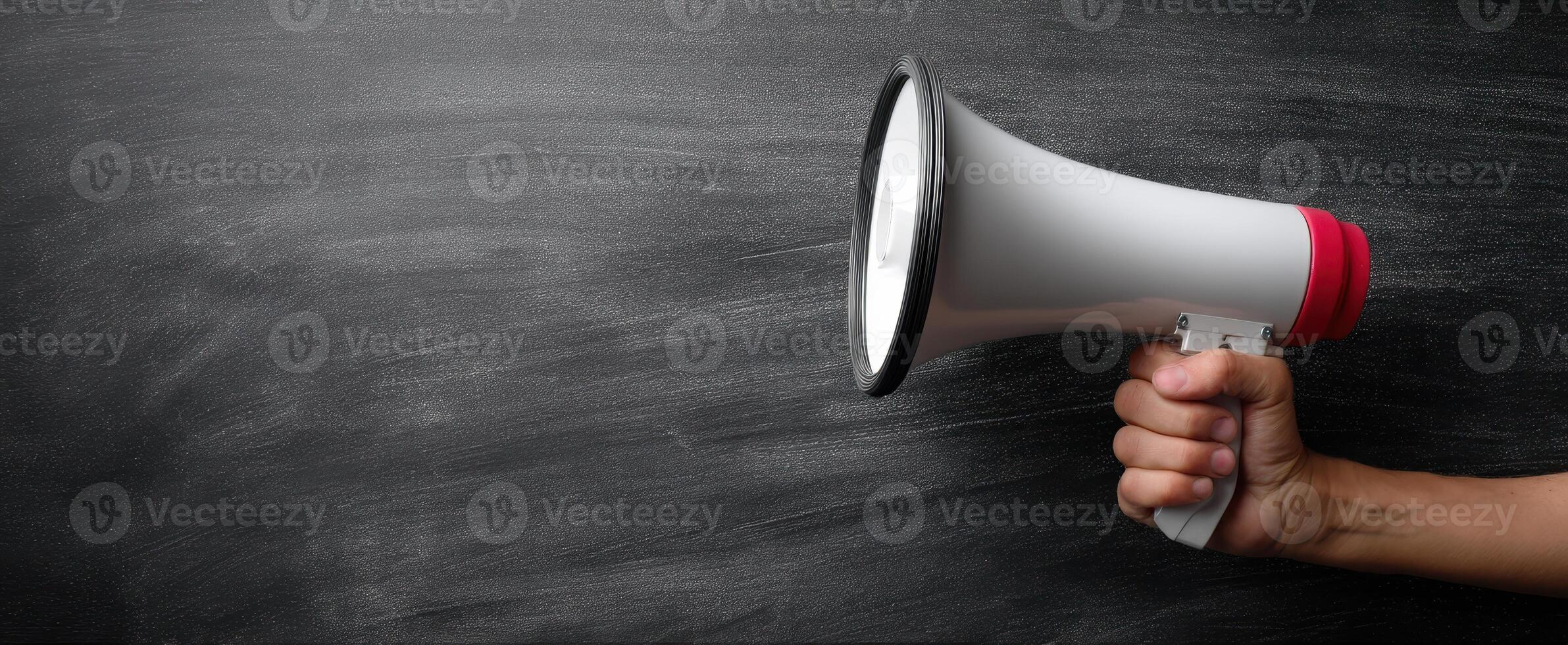 The megaphone held by a hand for making impactful announcements and communication. photo