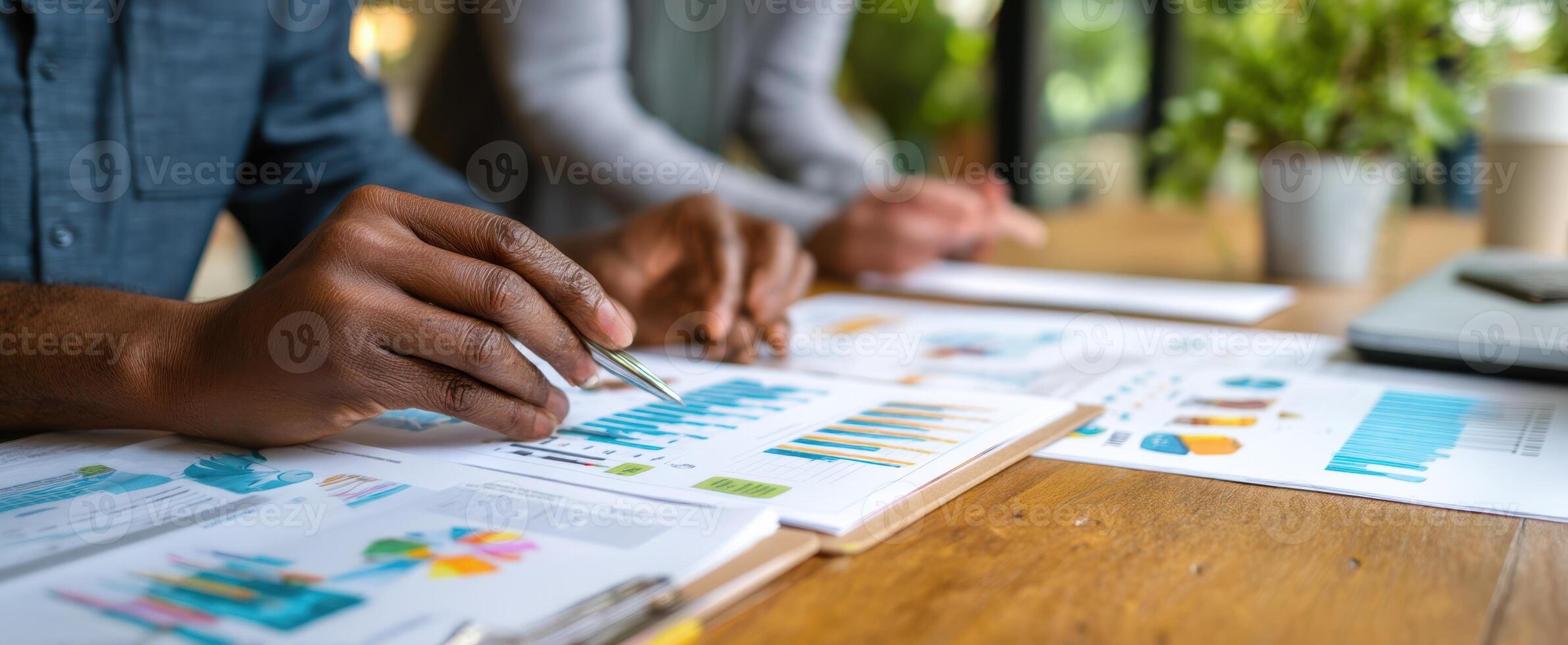 The hands reviewing analytics reports in a collaborative office environment. photo