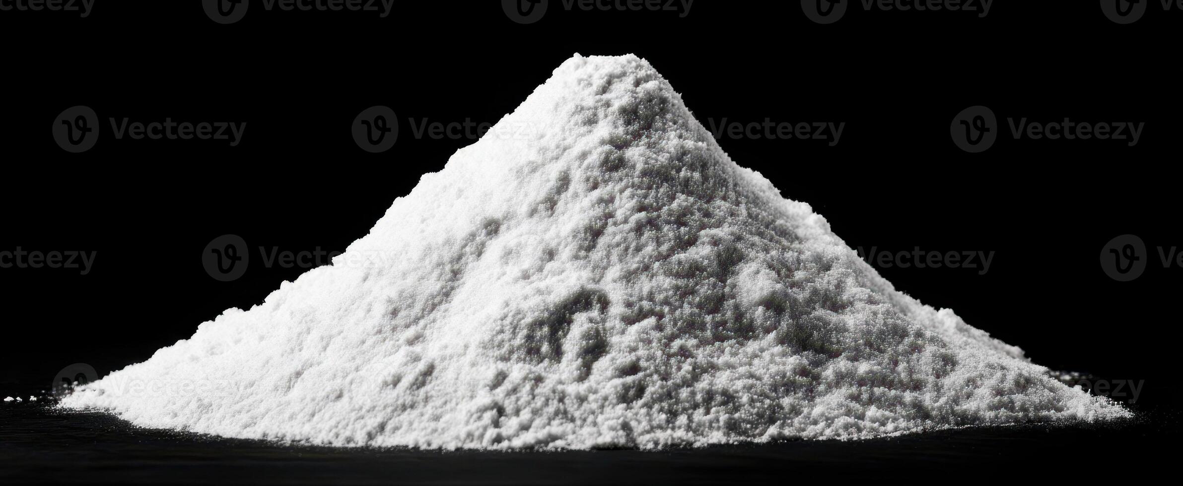 The mound of white salt on a dark background showcasing culinary versatility. photo