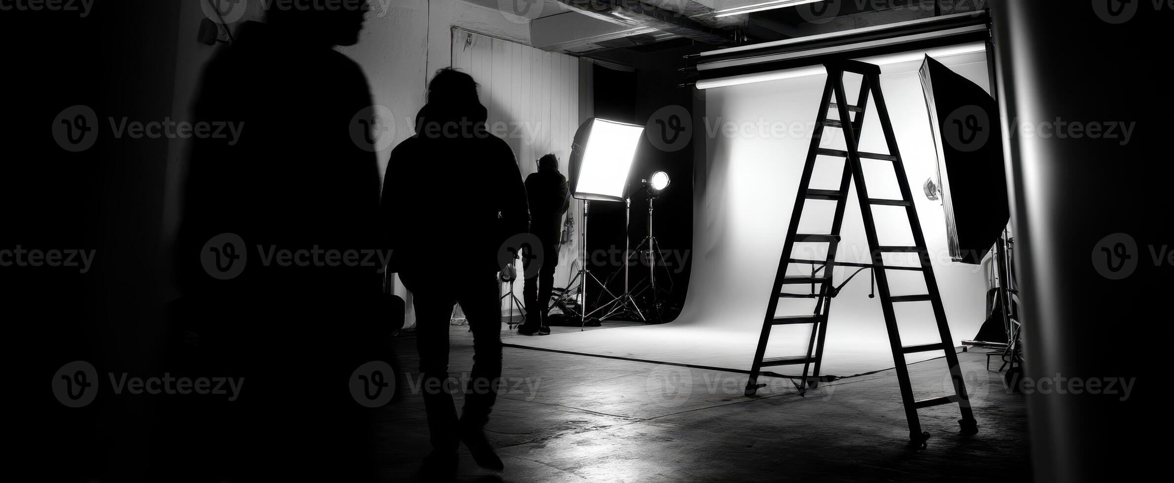 The dramatic studio setup featuring silhouettes and photography equipment in black and white. photo