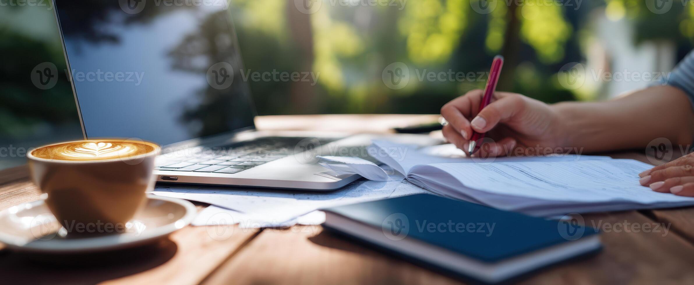The serene workspace featuring a laptop, coffee, and handwritten notes. photo