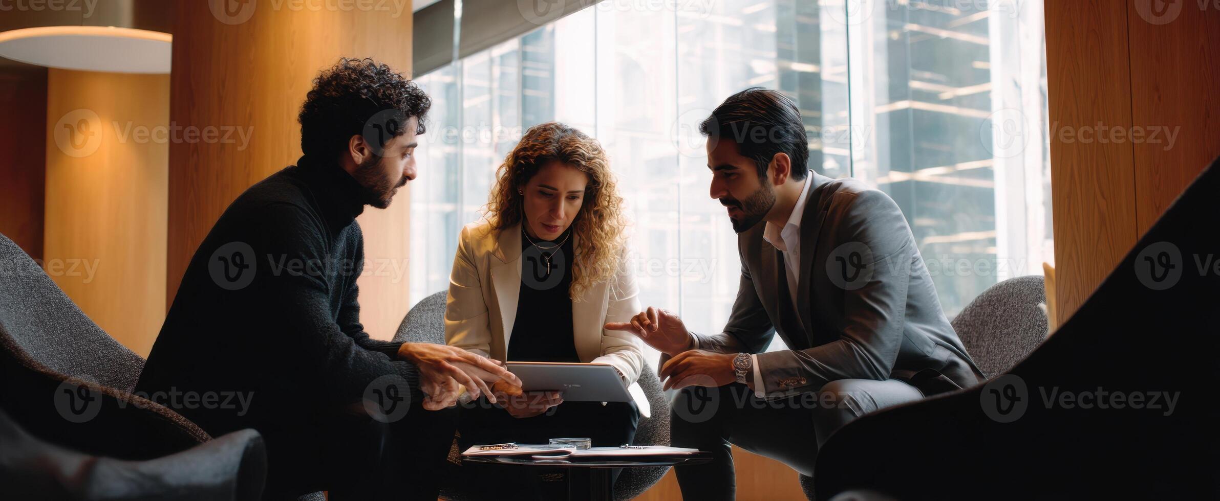 The professionals engaging in a collaborative meeting with a tablet in a modern office. photo