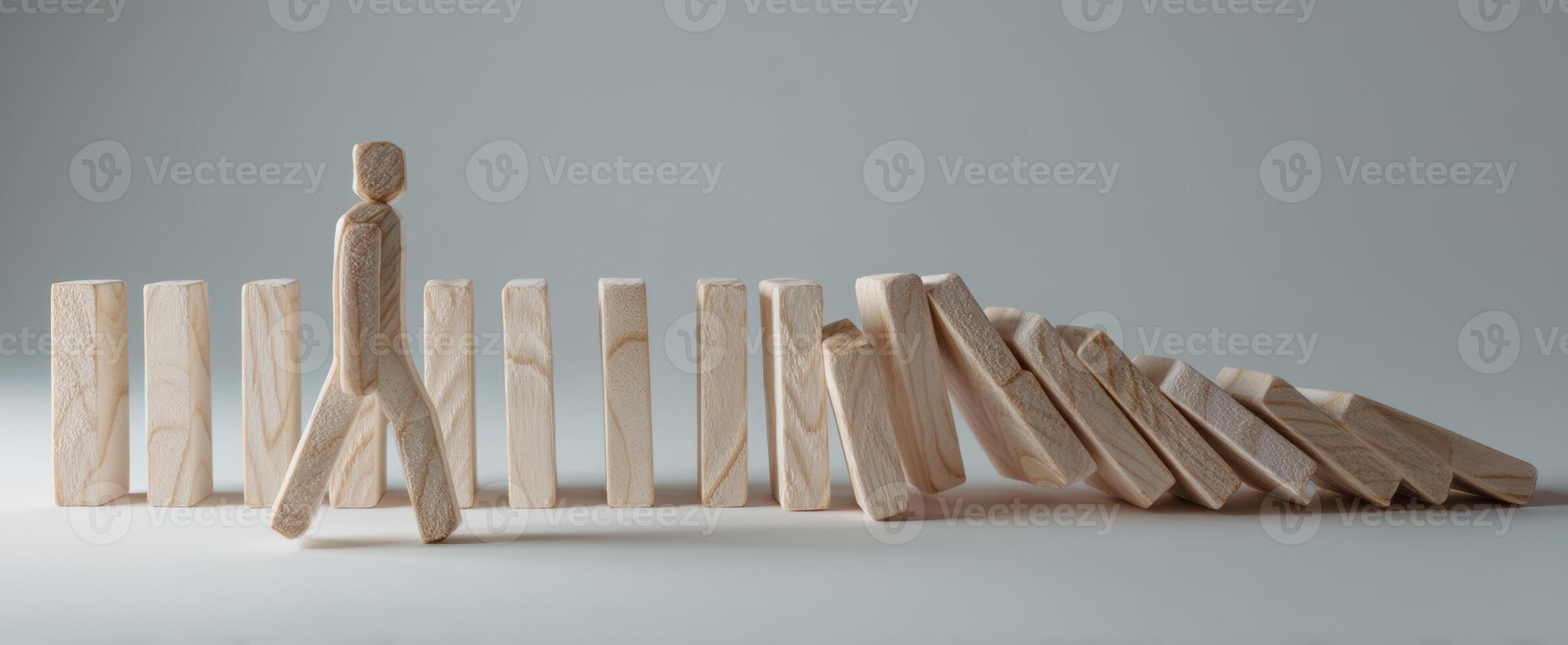 The wooden figure navigating a path among falling dominoes as a metaphor for challenges. photo