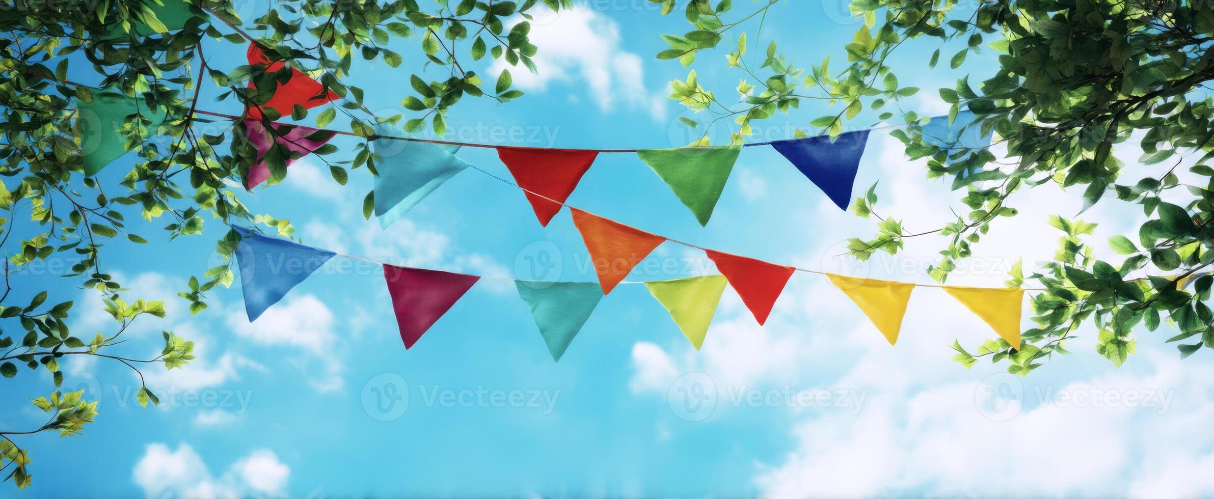 The colorful bunting swaying gently in the summer sky above the trees. photo