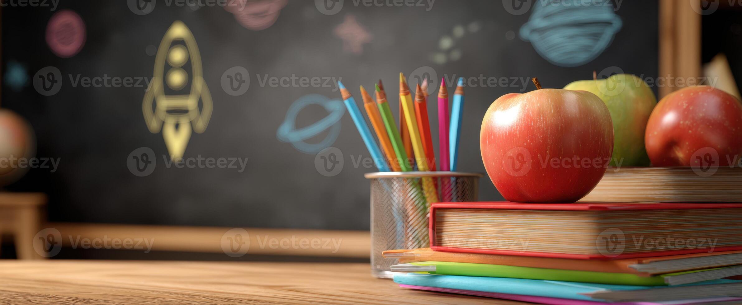 The vibrant apples and colorful stationery on a classroom desk. photo