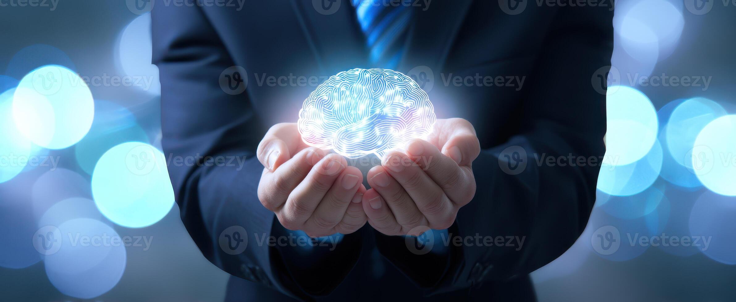 The businessman holds a glowing brain representing innovative ideas and technology. photo