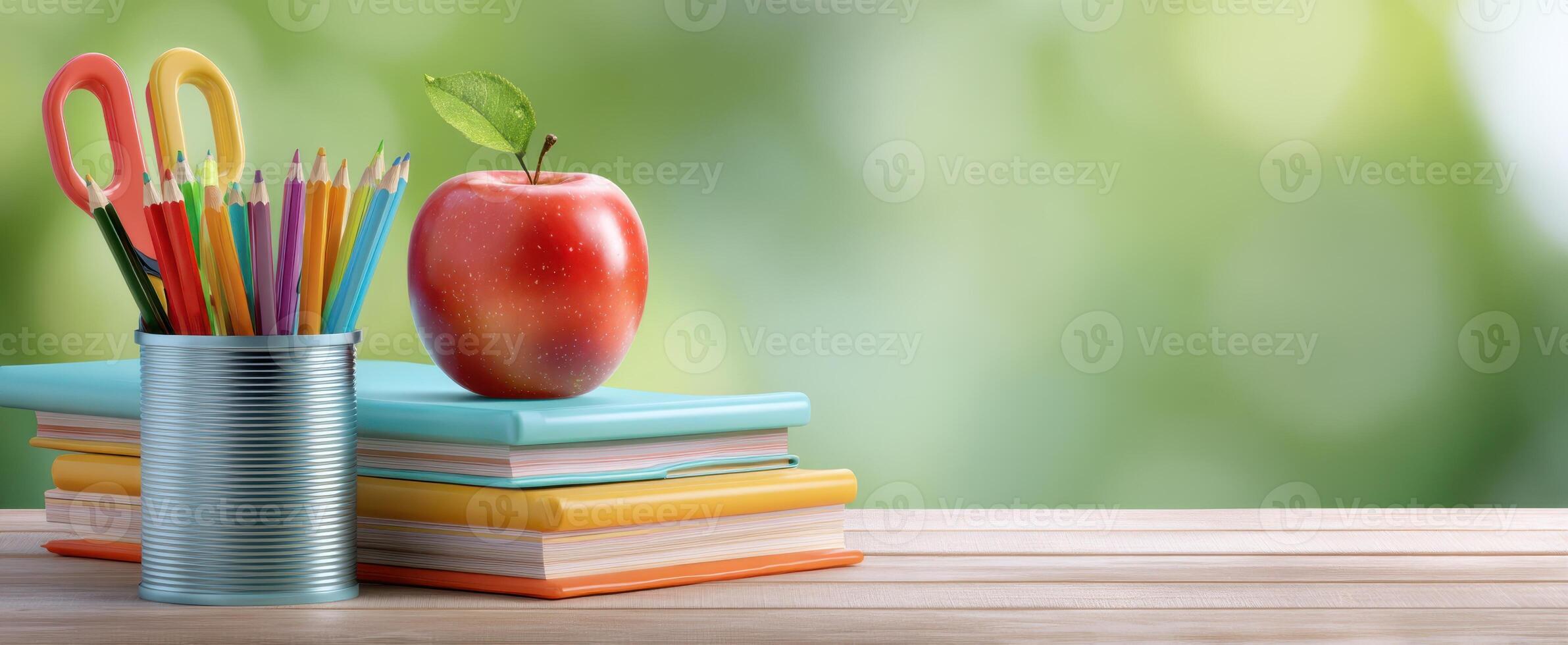 The colorful stationery arrangement with an apple on top of notebooks. photo