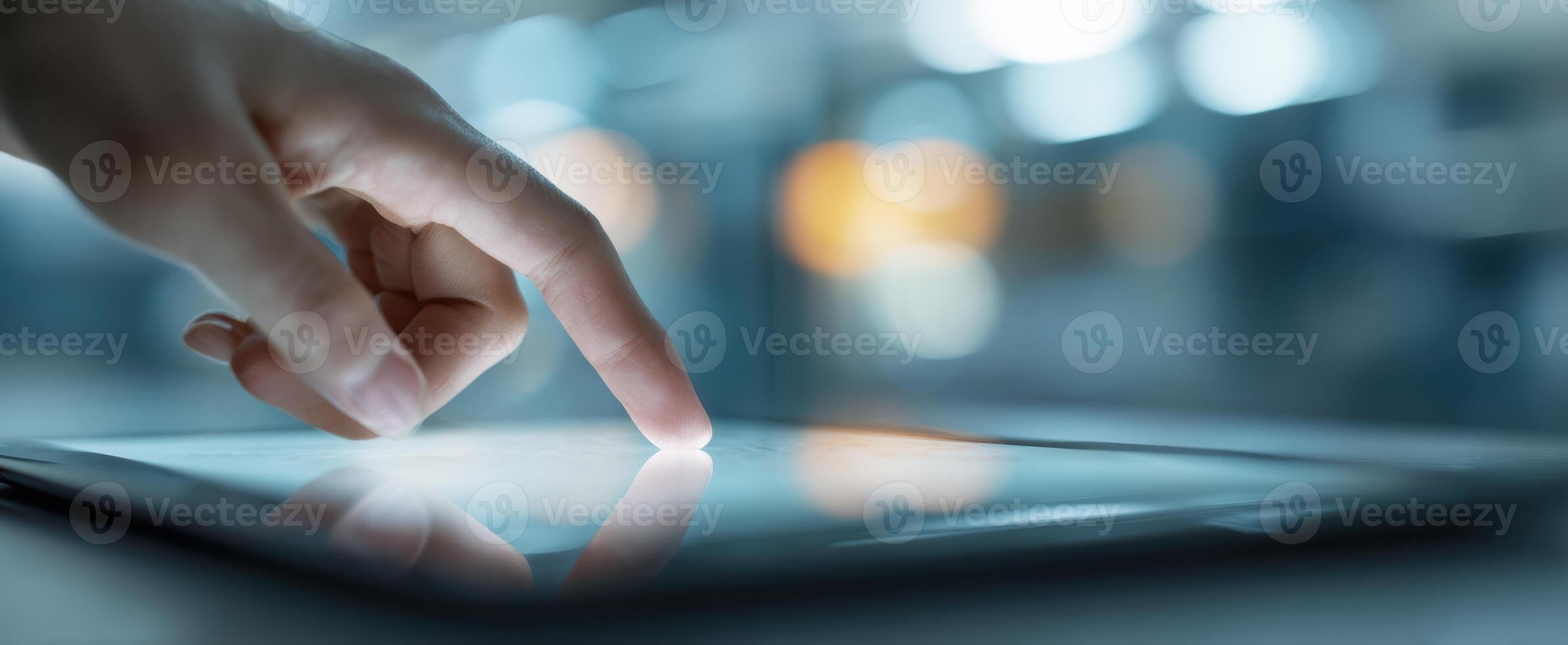 The hand interacting with a touchscreen tablet in a modern workspace environment. photo