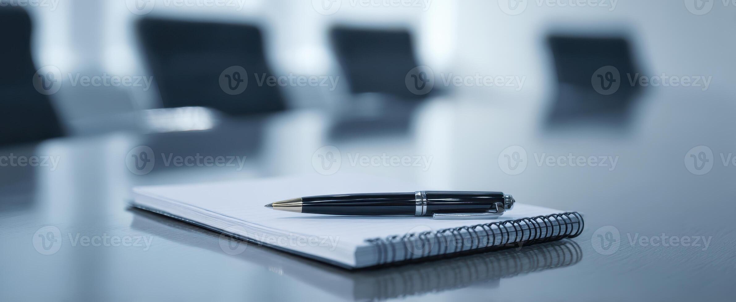 The elegant pen rests on a clean notebook in a modern conference room. photo
