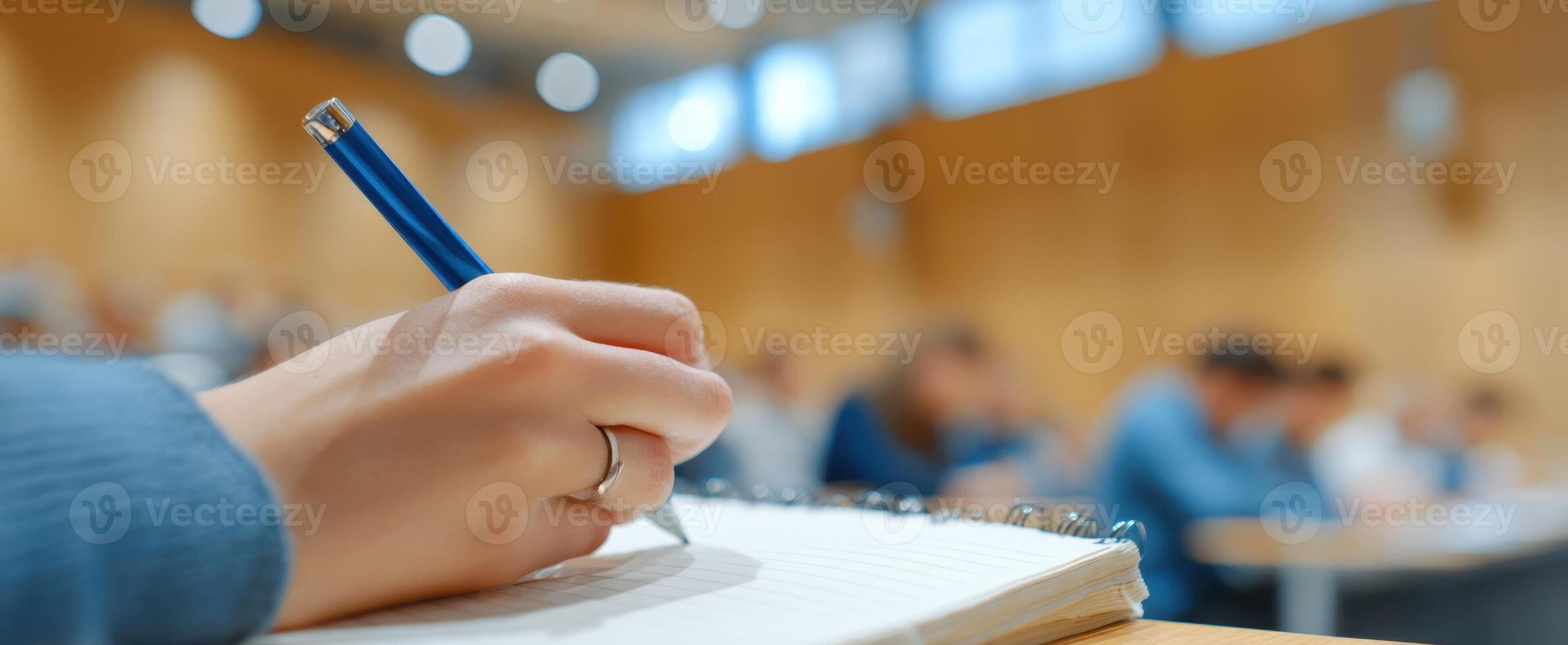 The student writing notes during an engaging classroom lecture session. photo
