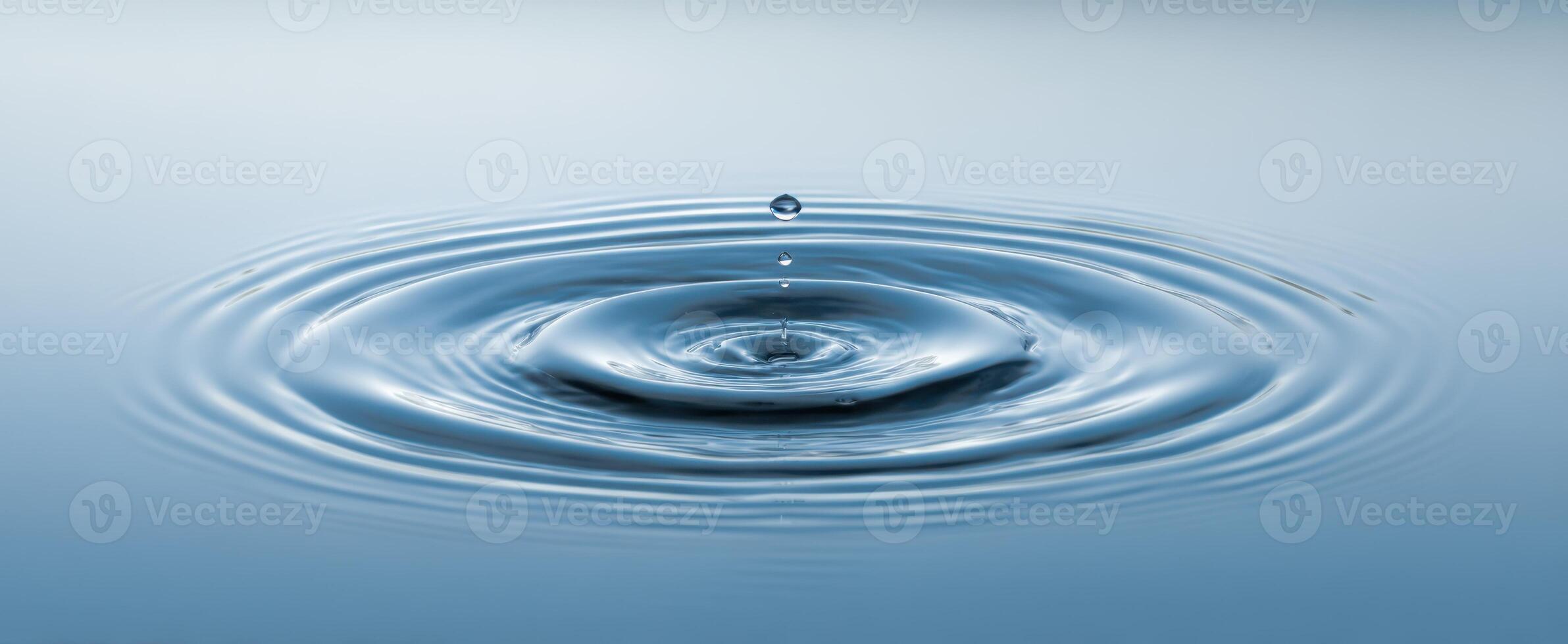 The tranquil water surface with ripples created by a single drop. photo