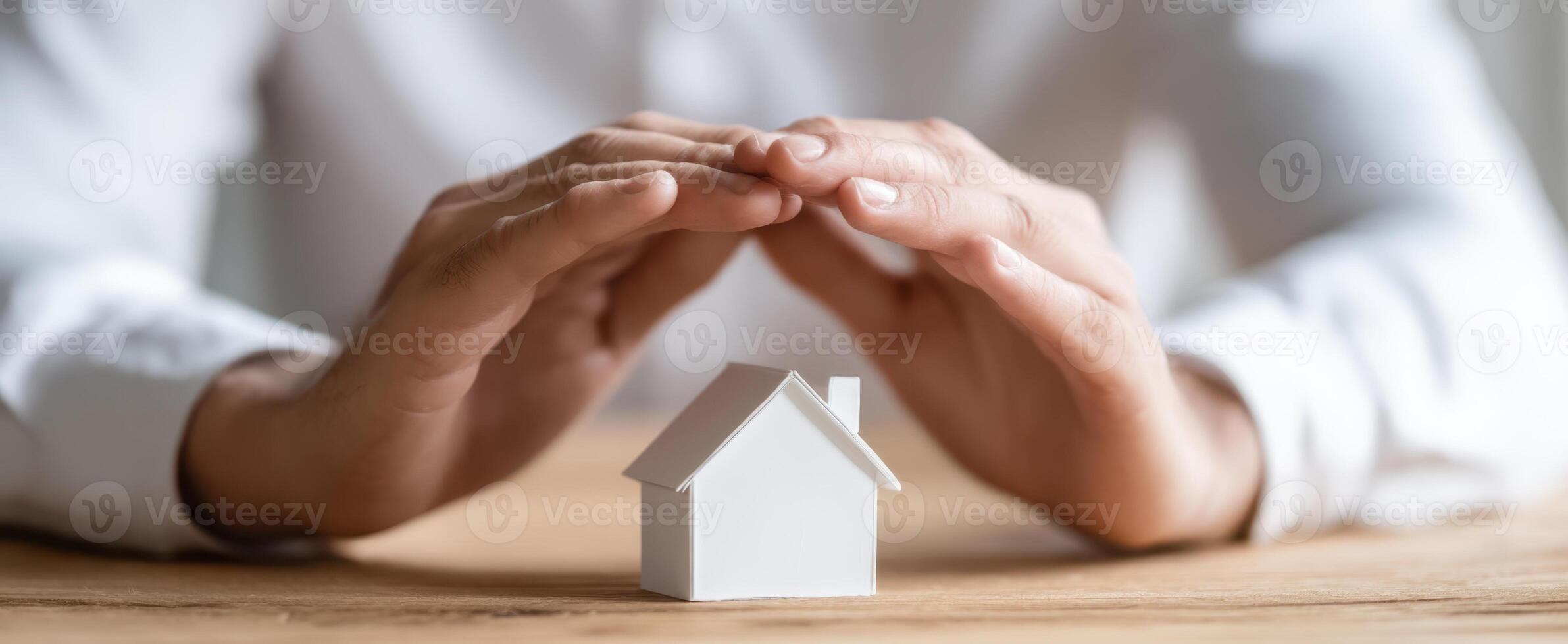 The hands protecting a small model house symbolizing security and investment. photo
