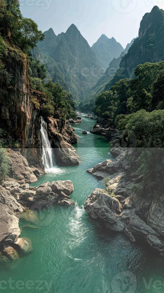 Glistening river flows through majestic mountains and lush greenery under a bright sky in a serene natural landscape photo