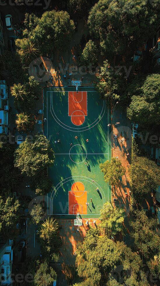 Basketball players enjoy an afternoon game on a vibrant court surrounded by lush trees in a city park photo