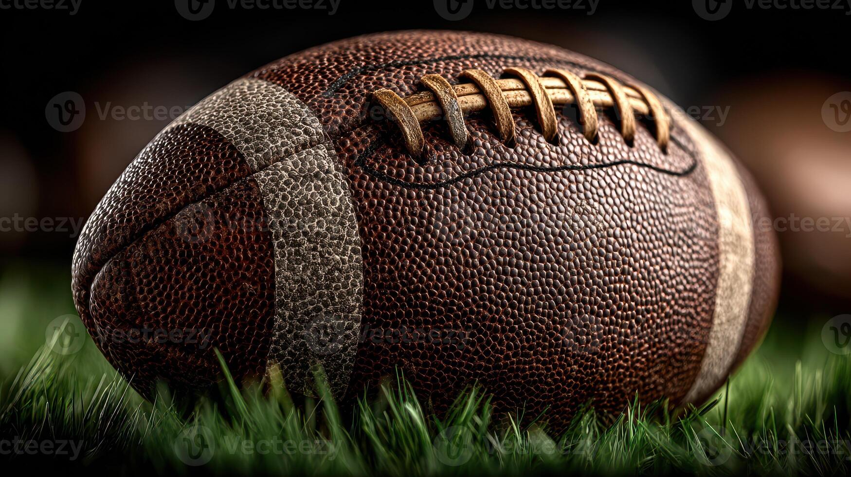 Classic brown football resting on green grass, ready for action during a game under bright stadium lights photo