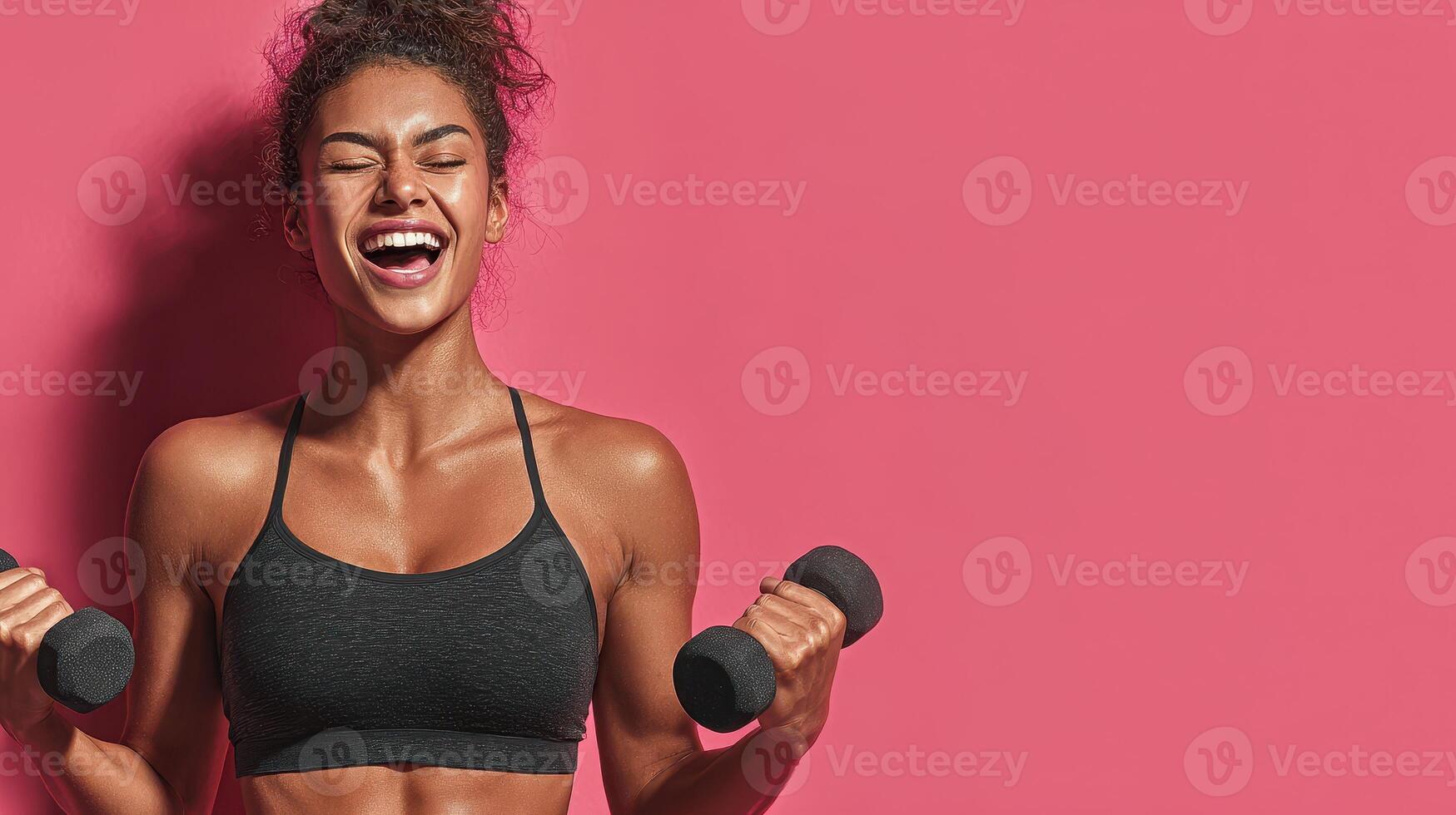 Young woman enjoying a workout with dumbbells against a vibrant pink background in a bright fitness studio photo
